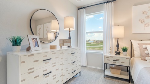 Pecan Creek Model Texas Cali secondary bedroom with carpeted flooring and window for lighting.