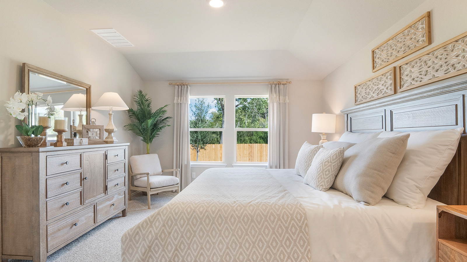 Pecan Creek Model Texas Cali primary bedroom with carpeted flooring and windows for lighting.