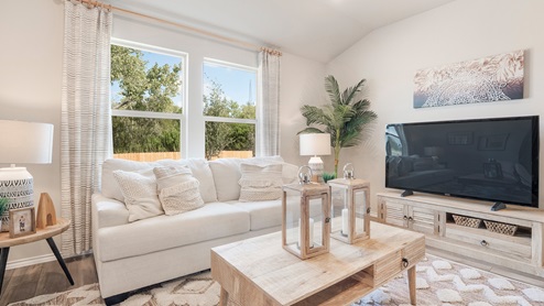 Pecan Creek Model Texas Cali living room with windows and view of back yard.