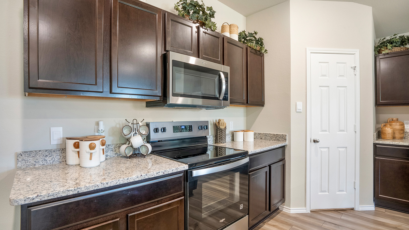 Pecan Creek Model Texas Cali kitchen with dark cabinets and granite countertops.