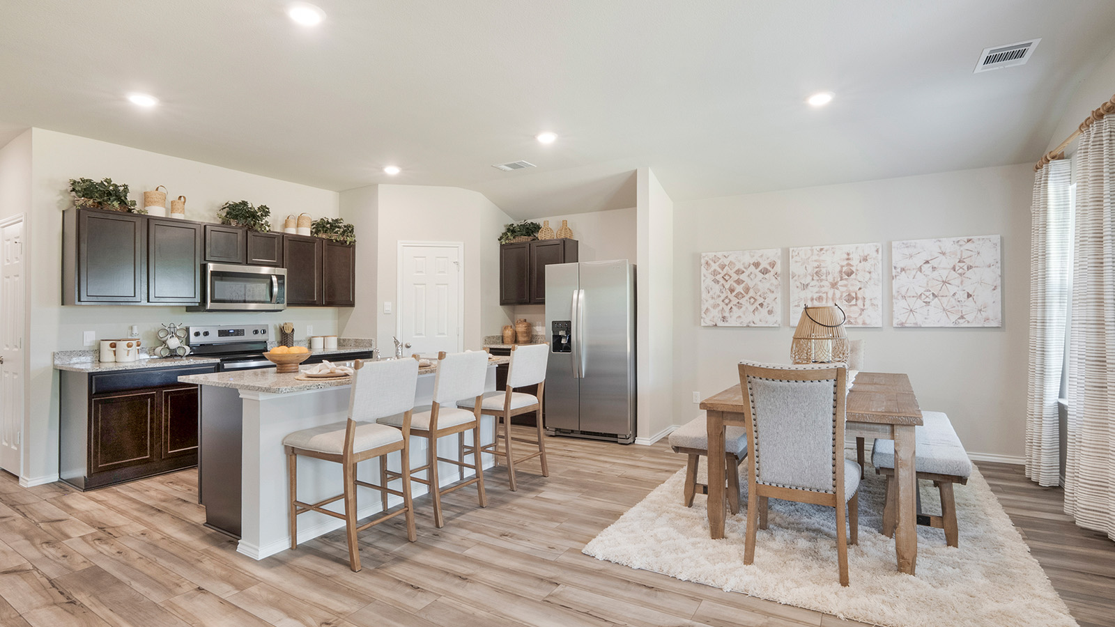 Pecan Creek Model Texas Cali kitchen with center kitchen island an view of open concept dining room.