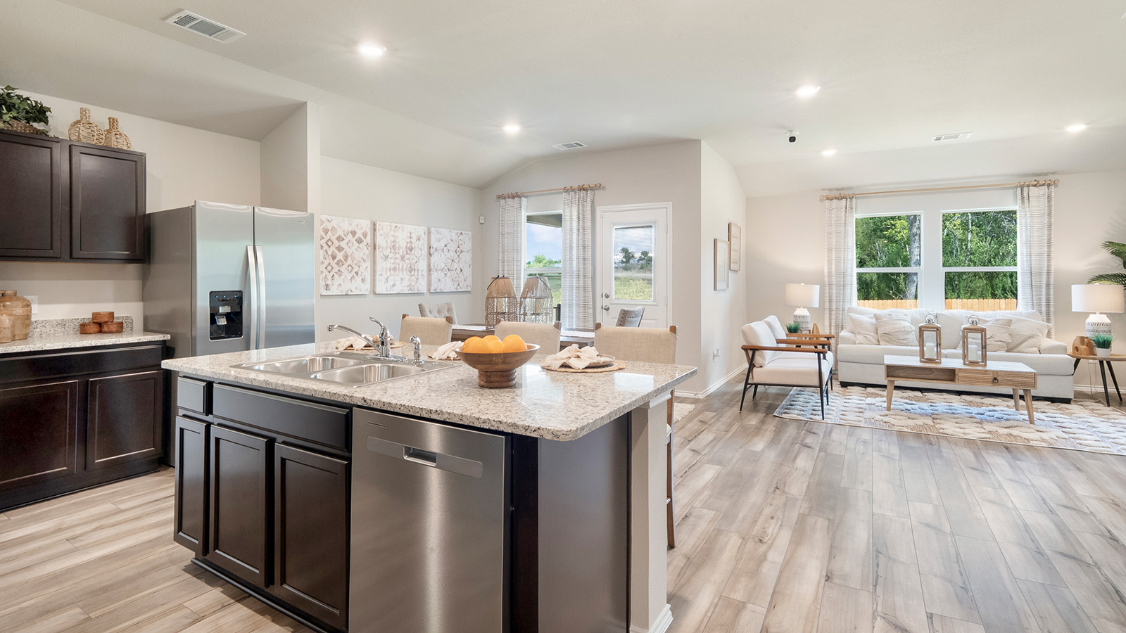 Pecan Creek Model Texas Cali kitchen with center kitchen island with view of open concept living room and dining room.