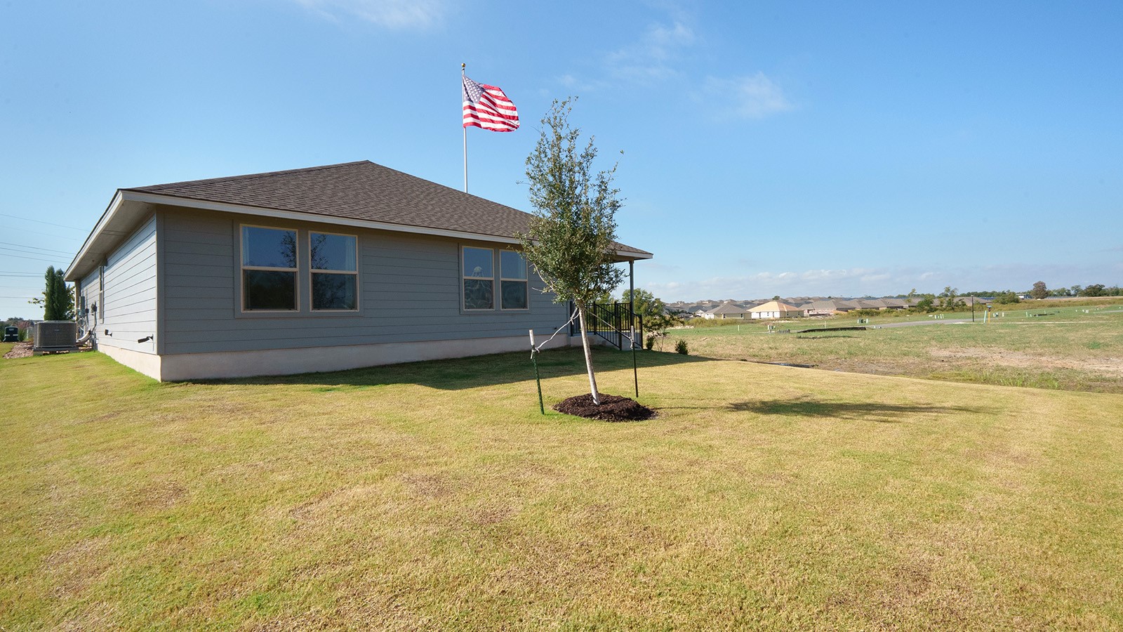 Pecan Creek Model Texas Cali Back Exterior with view of back yard.