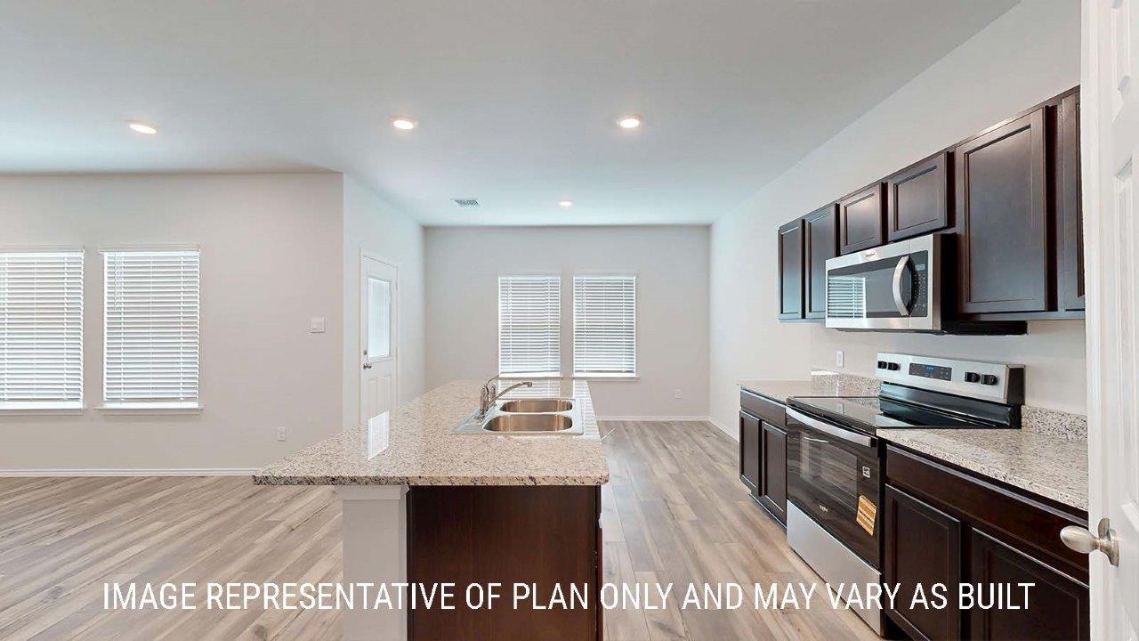 Emma kitchen with center kitchn island with granite countertops and view of dining room.