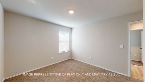 Texas Cali secondary bedroom with carpet flooring and window.