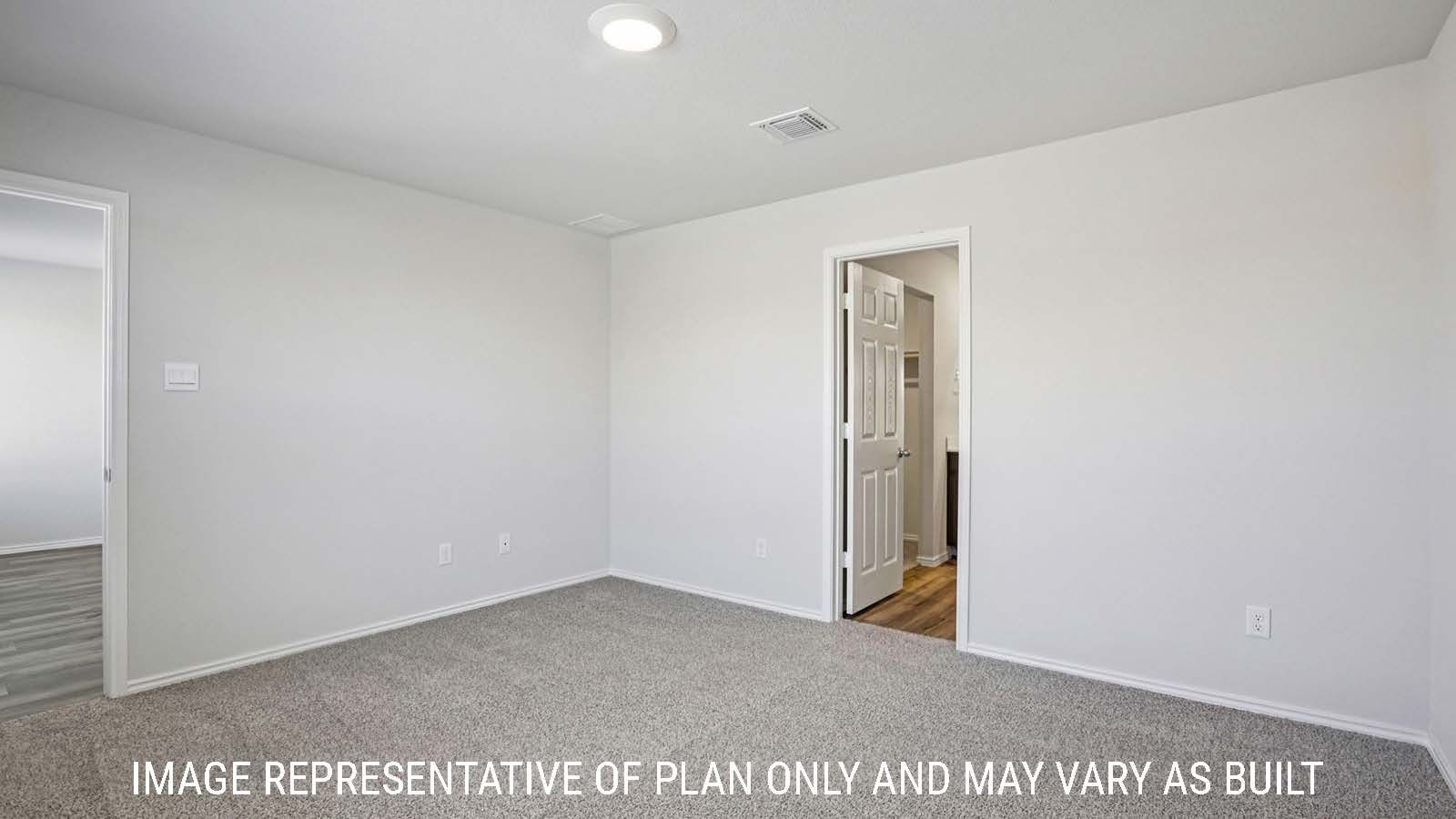 Caprock primary bedroom with carpeted flooring and view of primary bathroom.