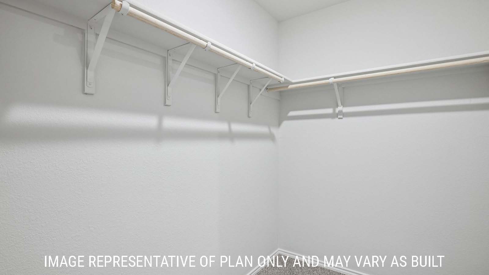 Caprock primary bedroom closet with carpeted flooring and shelving for storage.