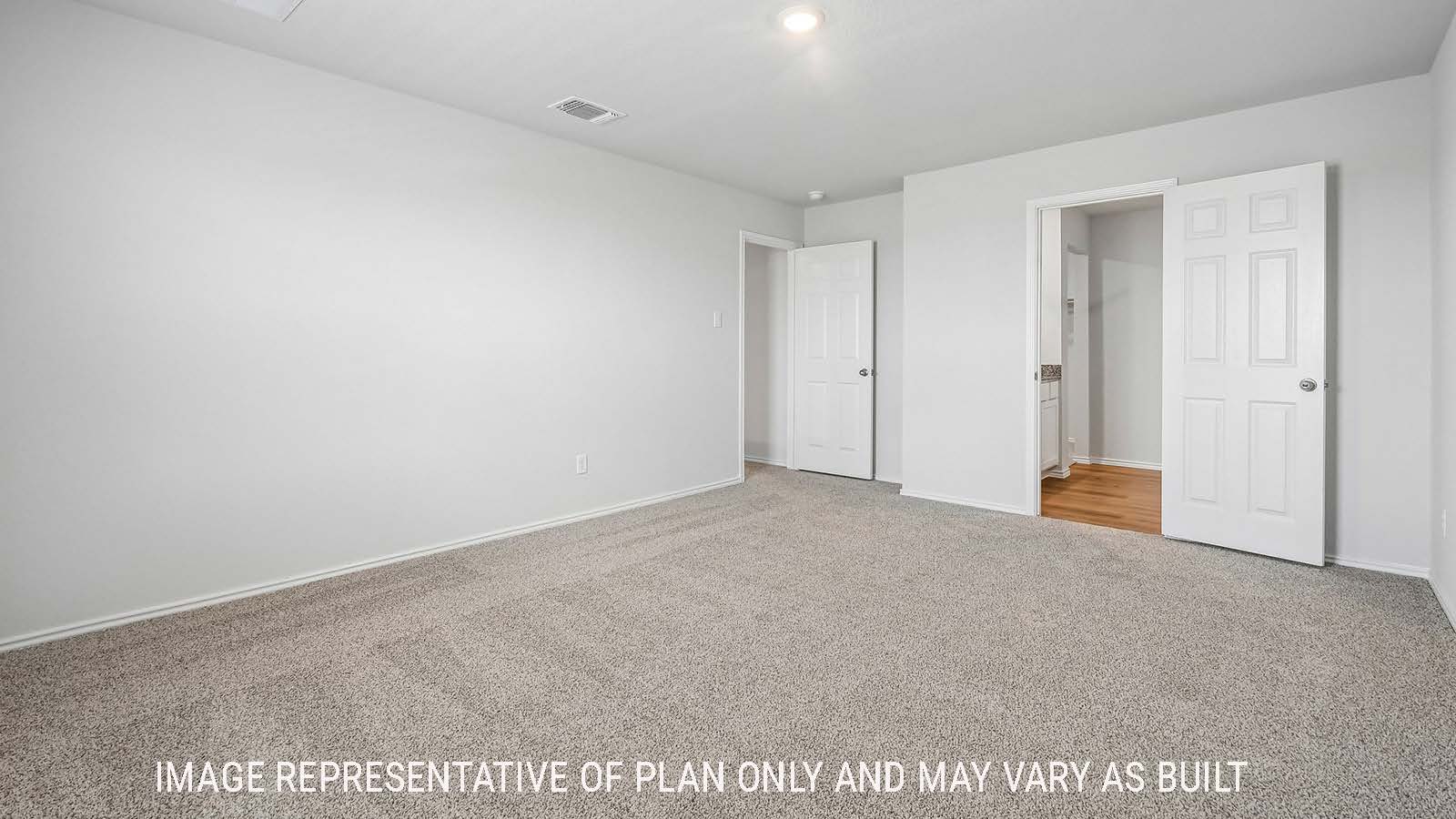 Davis primary bedroom with carpeted flooring and view of primary bathroom.