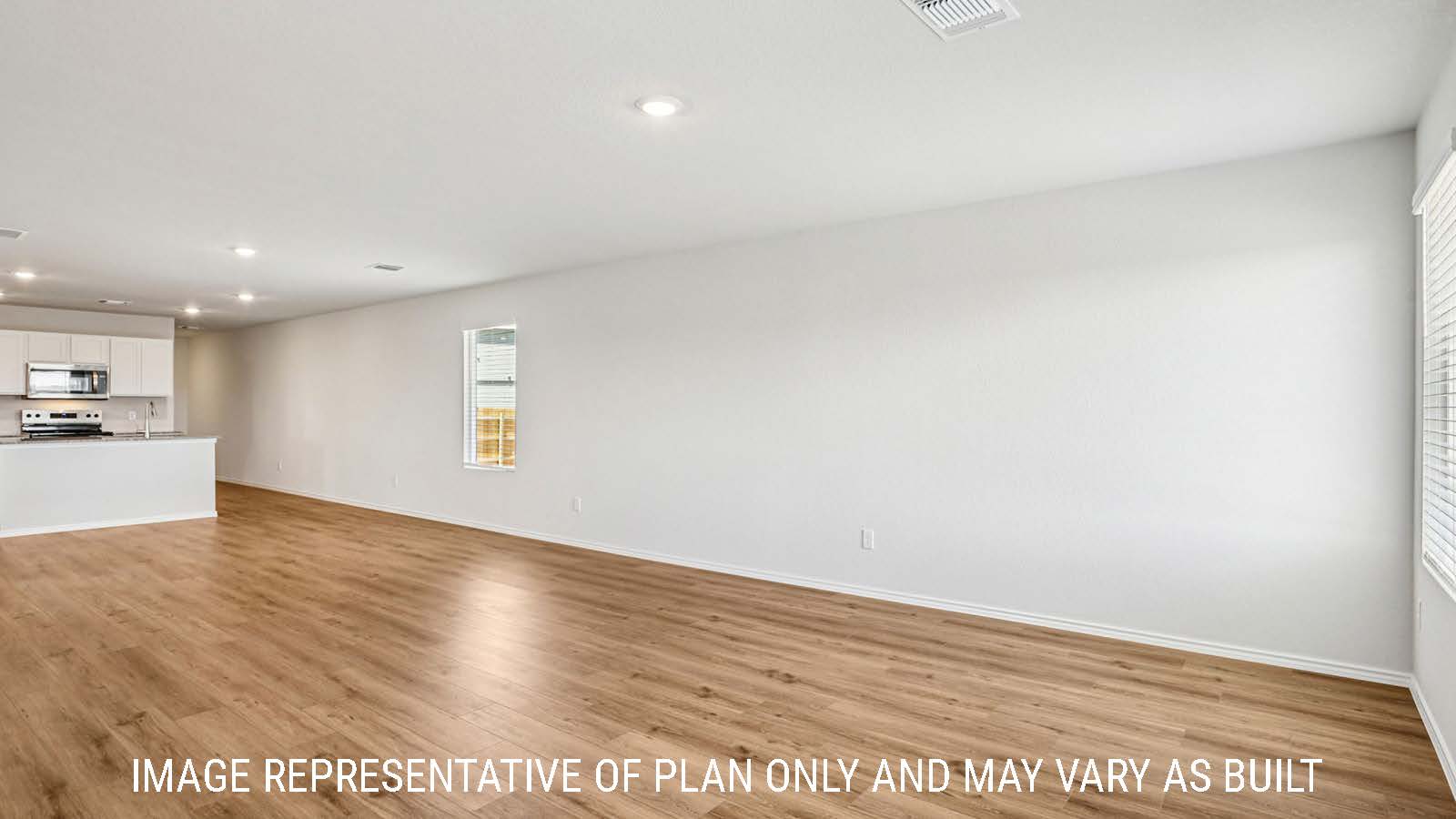 Estero living room with vinyl plank flooring and view of open concept dining room and kitchen.
