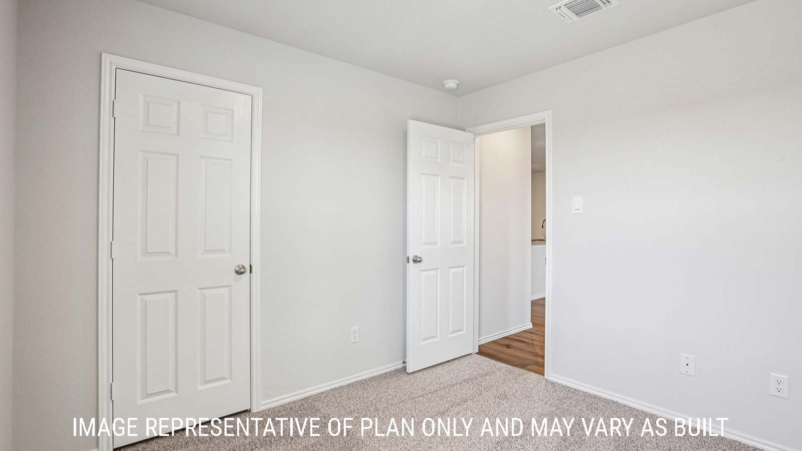 Estero secondary bedroom with carpeted flooring and view of hallway.