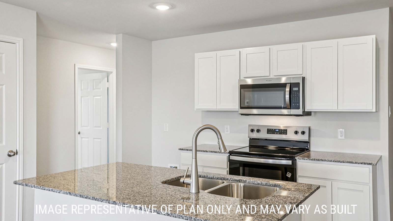 Estero kitchen with kitchen island with granite countertops and white cabinets.