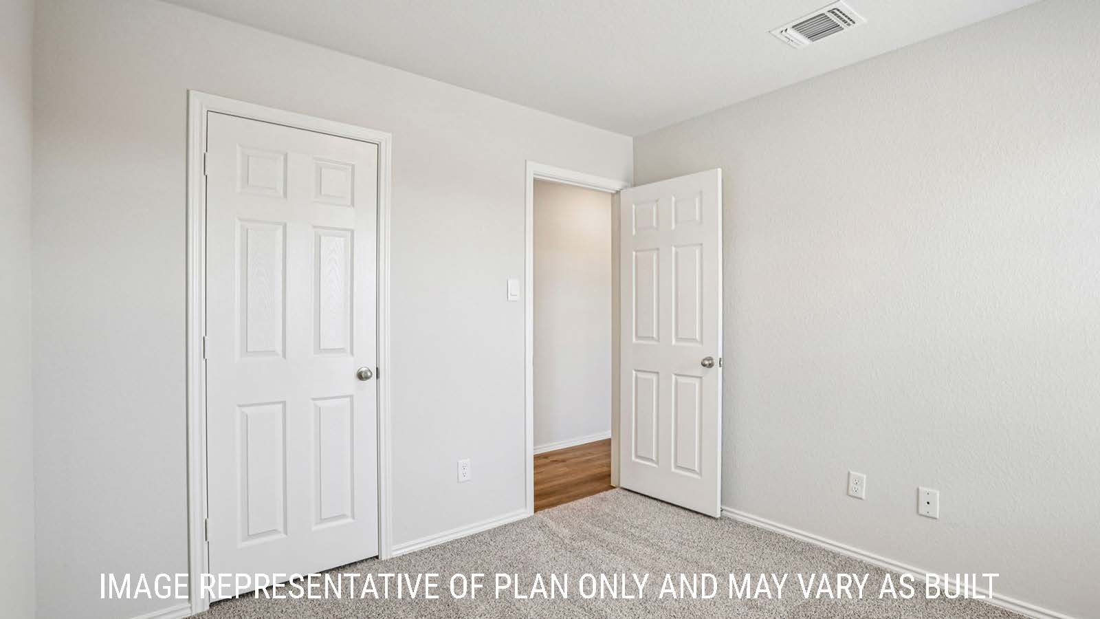 Estero secondary bedroom with carpeted flooring and view of hallway.