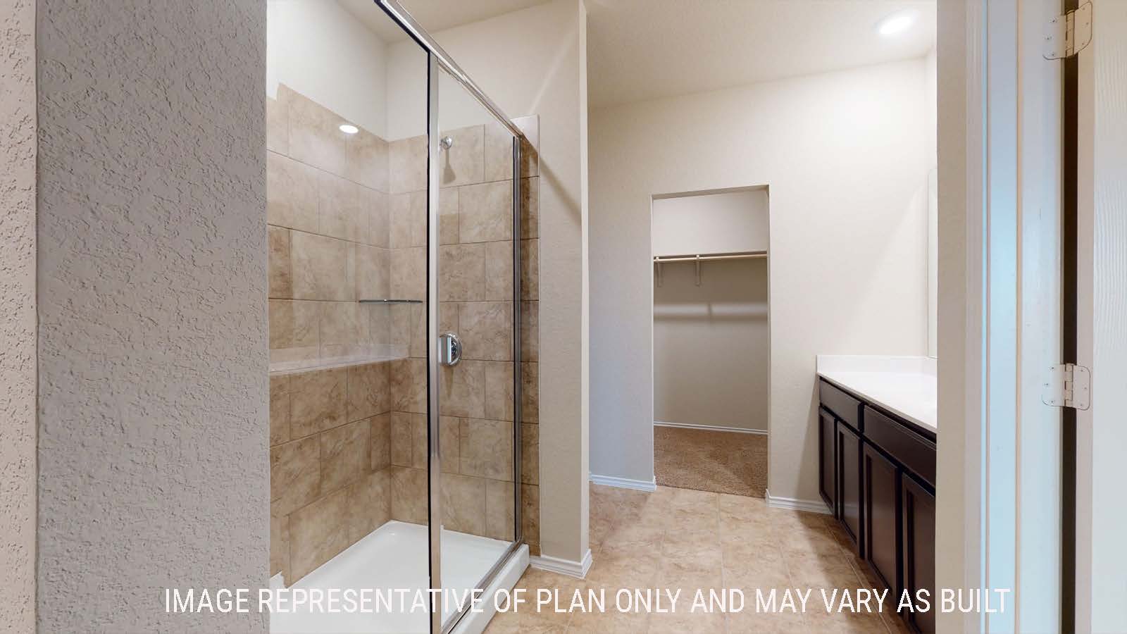 Perry primary bathroom with walk-in shower and vanity sink with view of walk-in closet.