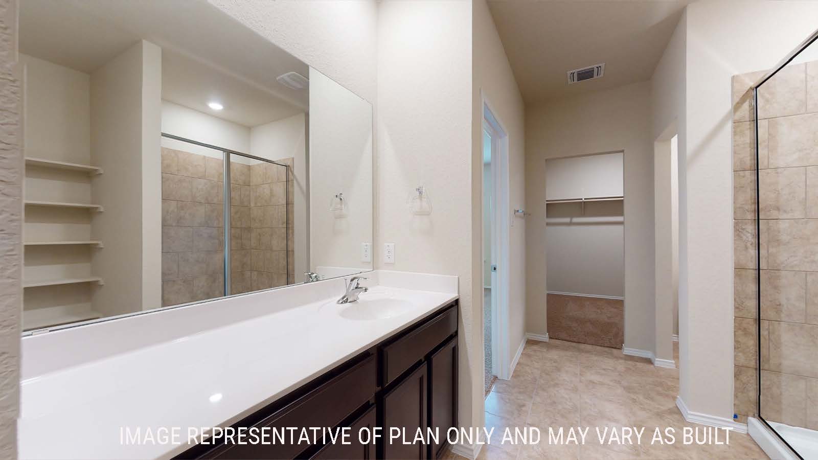 Perry primary bathroom with walk-in shower and vanity sink with view of walk-in closet.