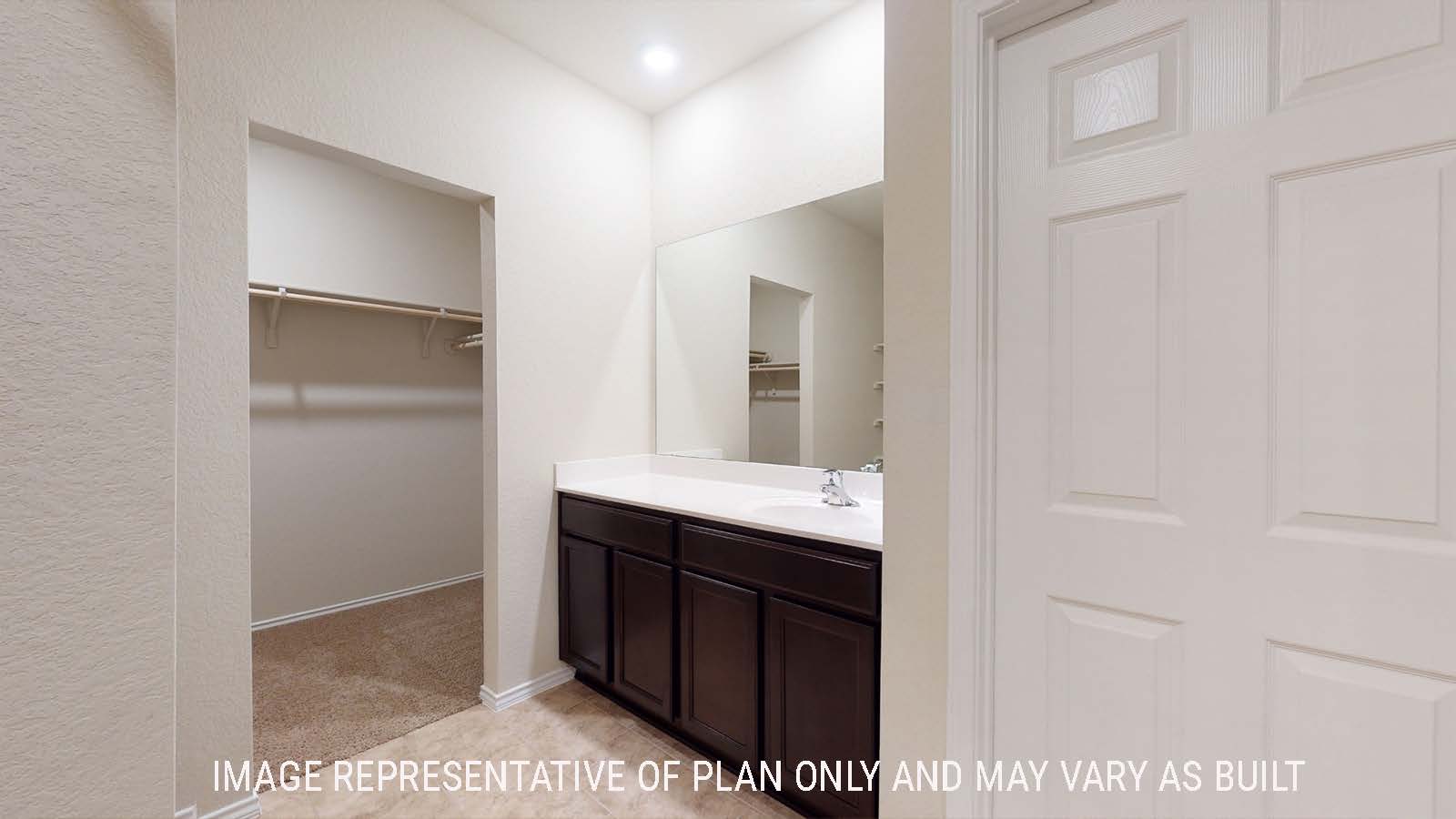 Perry study bathroom with vanity sink and view of walk-in closet.