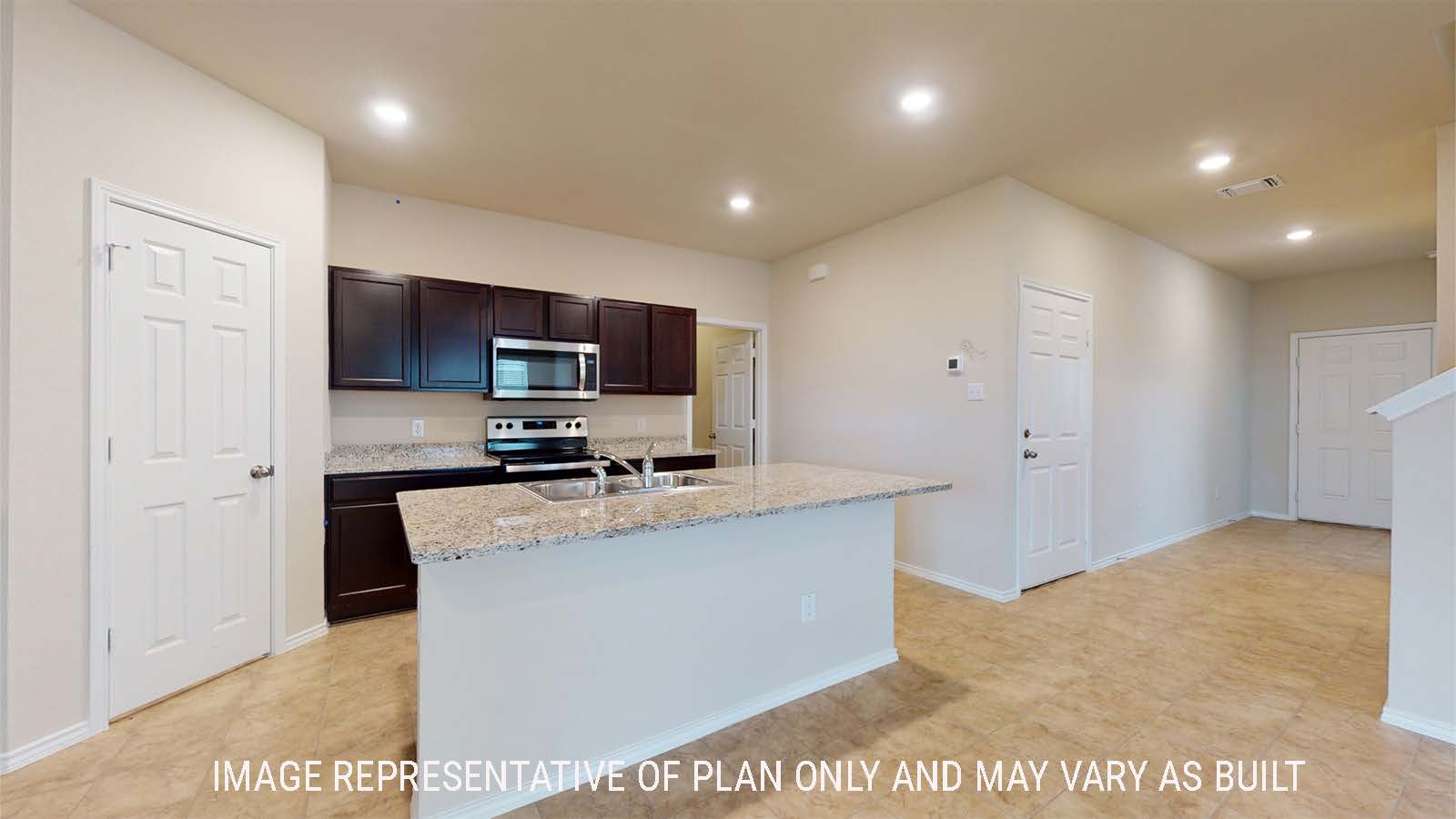 Perry kitchen with kitchen island and view of dark cabinets and view of front door entry way.
