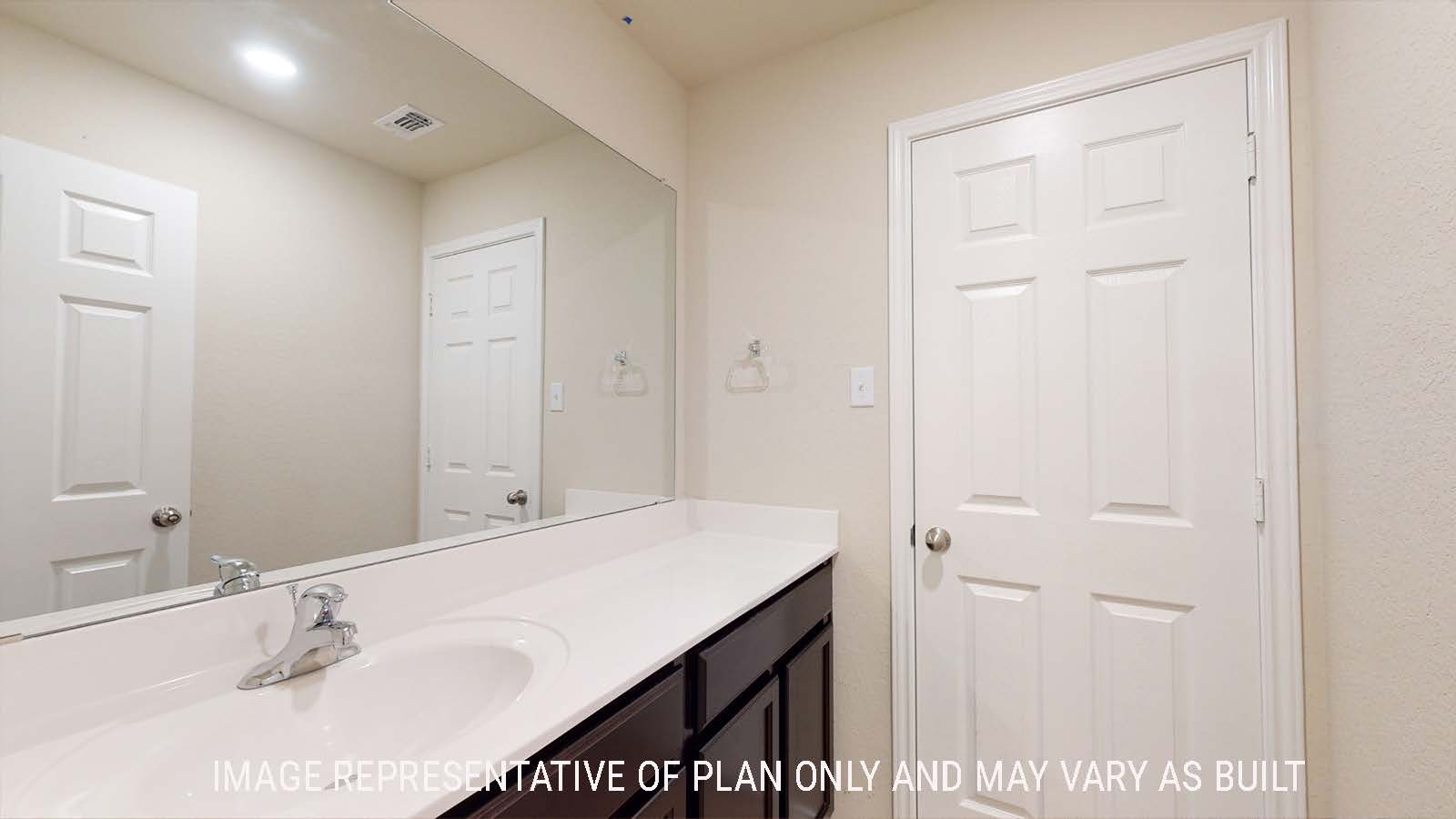 Perry secondary bathroom with vanity sink with dark cabinets and granite countertops.