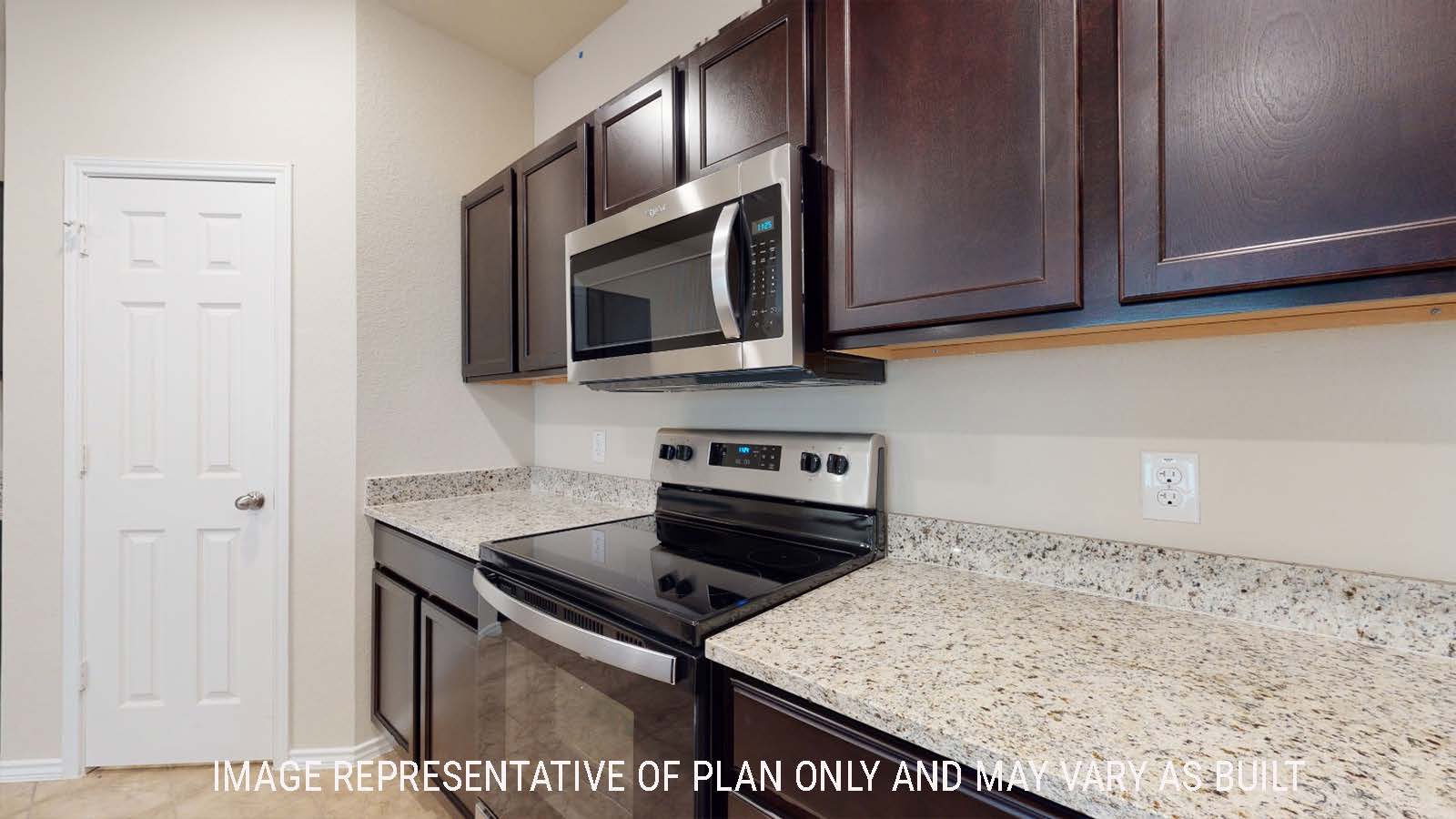 Perry kitchen with dark cabinets and granite countertops with view of panty door.