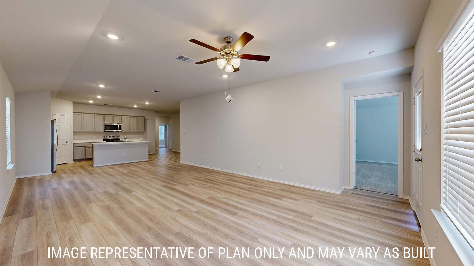 Gaven living room with vinyl plank flooring and view of open concept dining room and kitchen.