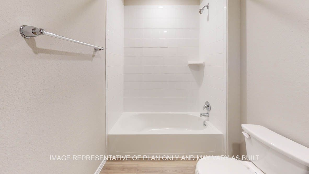 Camden secondary bathroom with combination tub and shower with white tile surround.