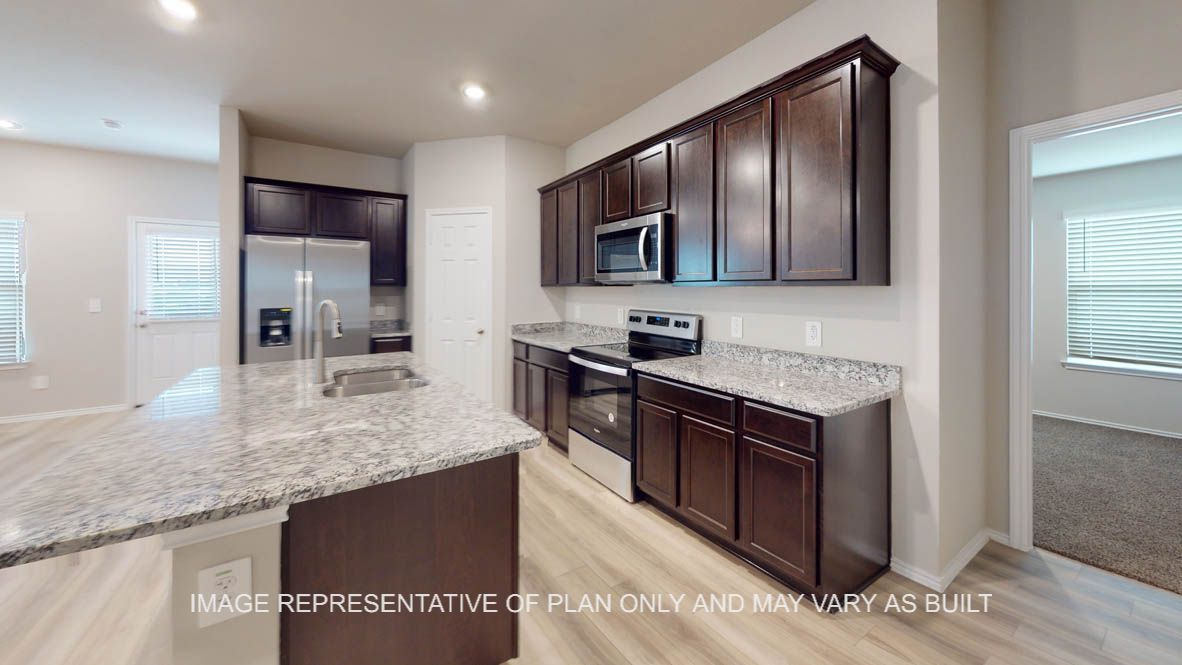 Camden kitchen with vinyl plank flooring, dark cabinets and granite countertops.