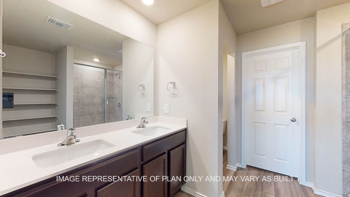 Fargo primary bath with dark cabinets and white countertops.