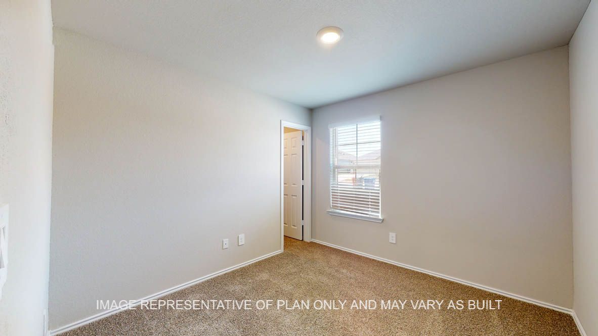 Fargo secondary bedroom with carpet flooring and window.