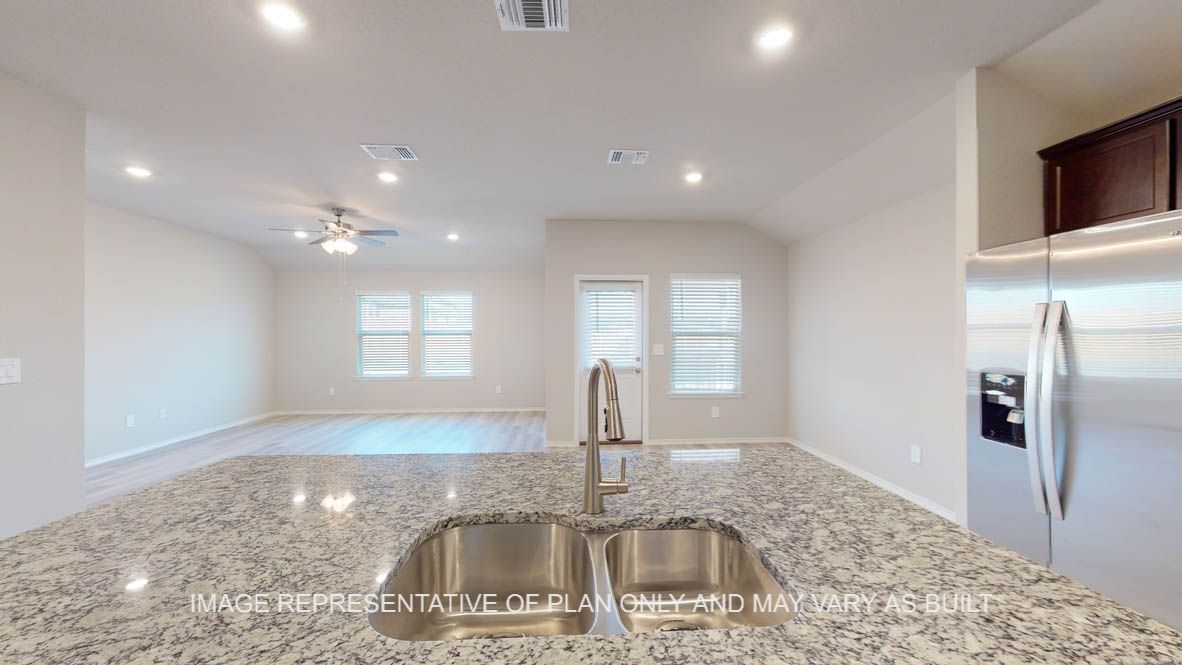 Texas Cali kitchen with large island and granite countertop with dark cabinets.