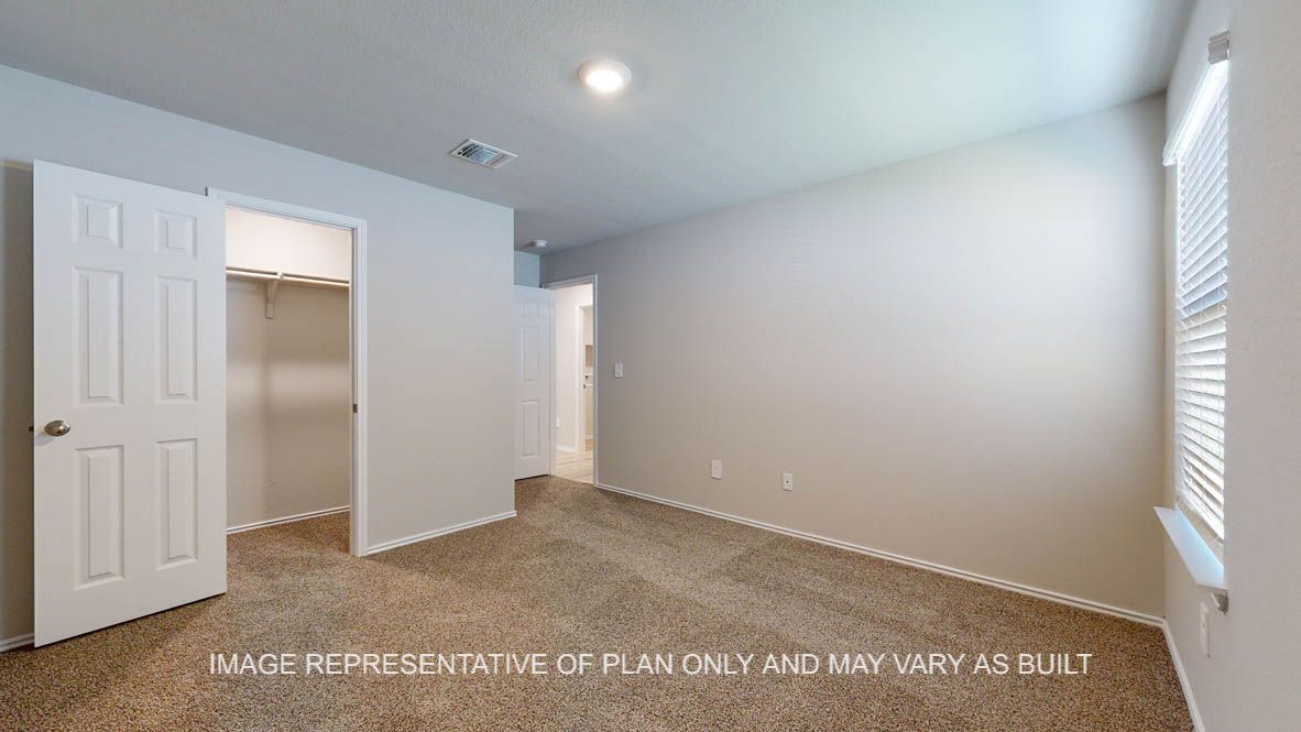 Seabrook secondary bedroom with carpet flooring and windows.