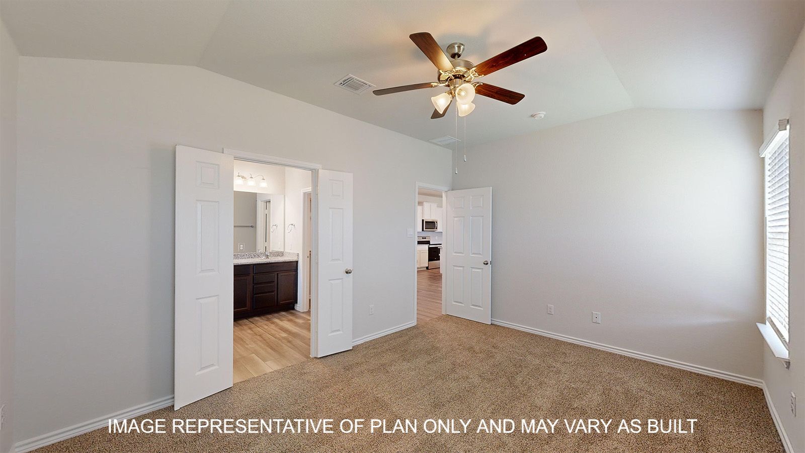 Dakota primary bedroom with carpet flooring and French doors into primary bathroom.