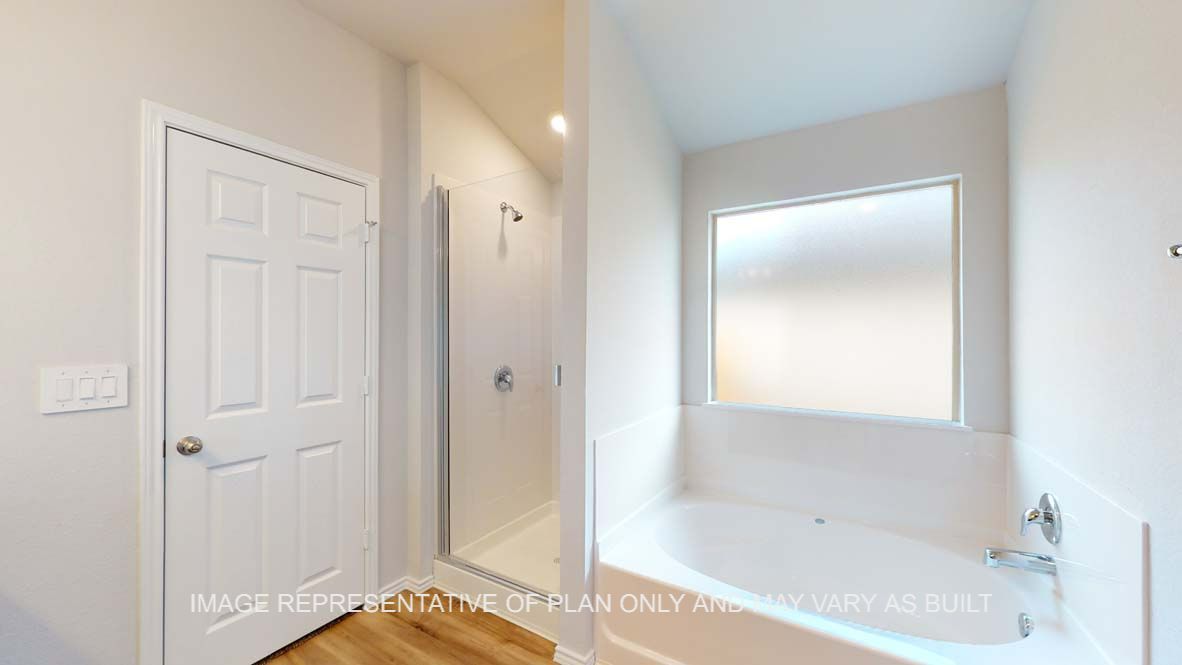 Roosevelt primary bathroom with separate tub and shower with clear glass enclosure.