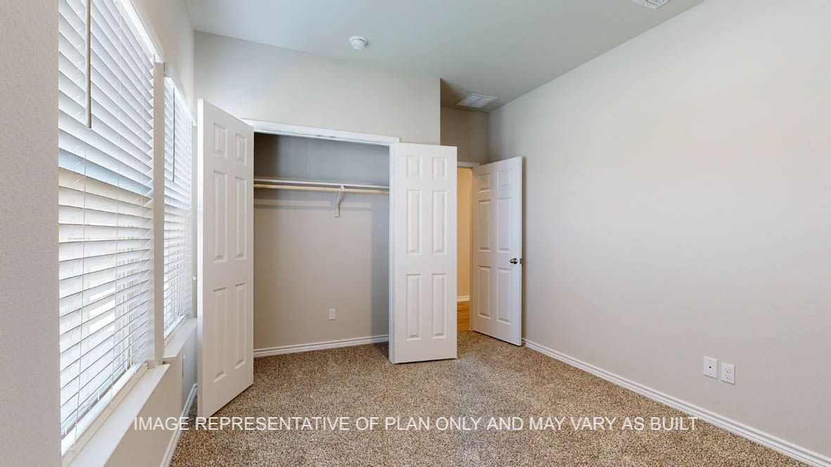 Richmond secondary bedroom with carpet flooring and closet and windows.