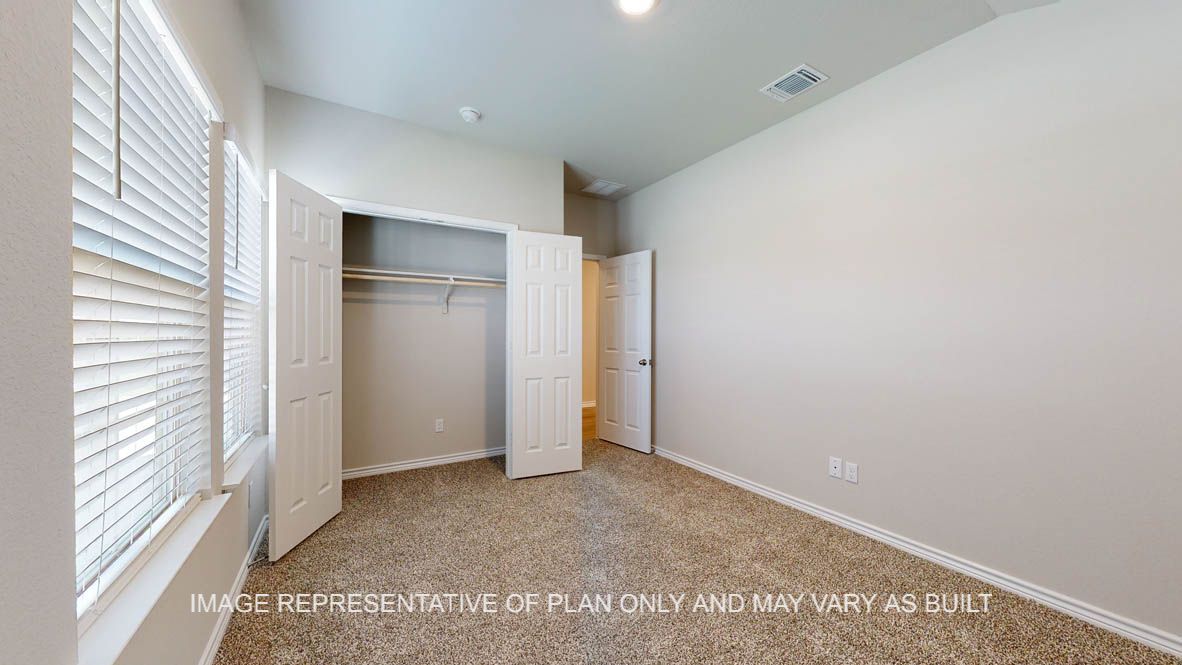 Richmond secondary bedroom with carpet flooring and closet and windows.