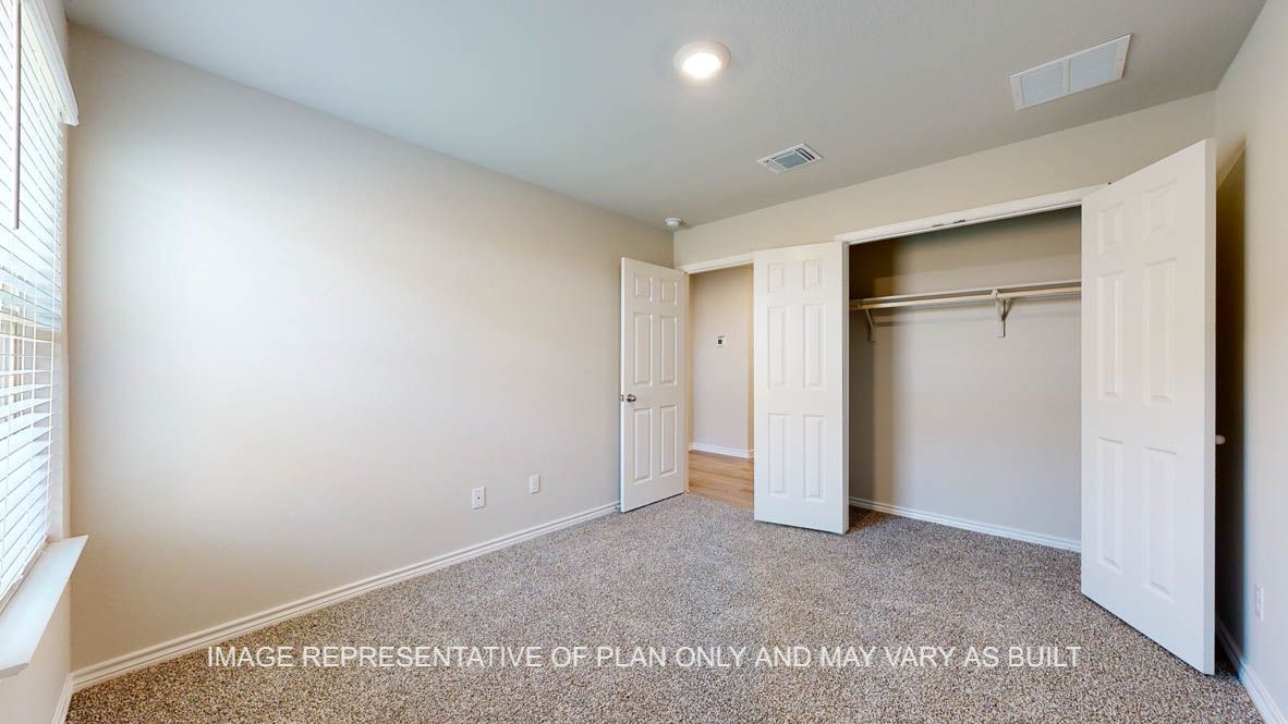 Richmond secondary bedroom with carpet flooring and closet.