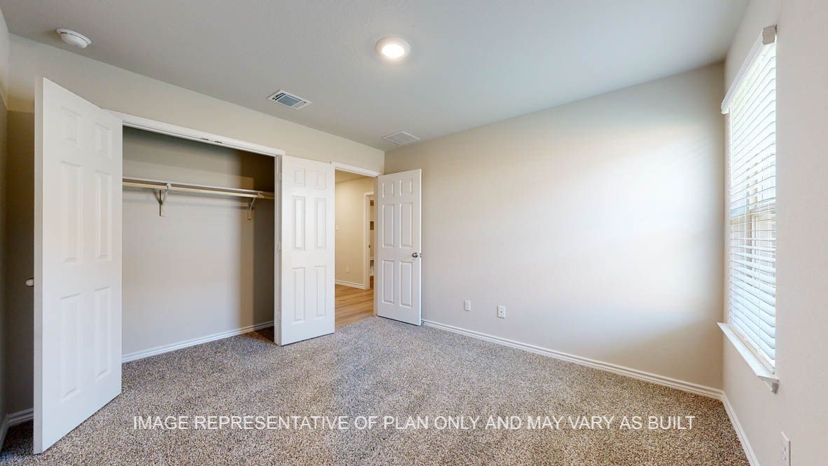 Richmond secondary bedroom with carpet flooring and closet and windows.