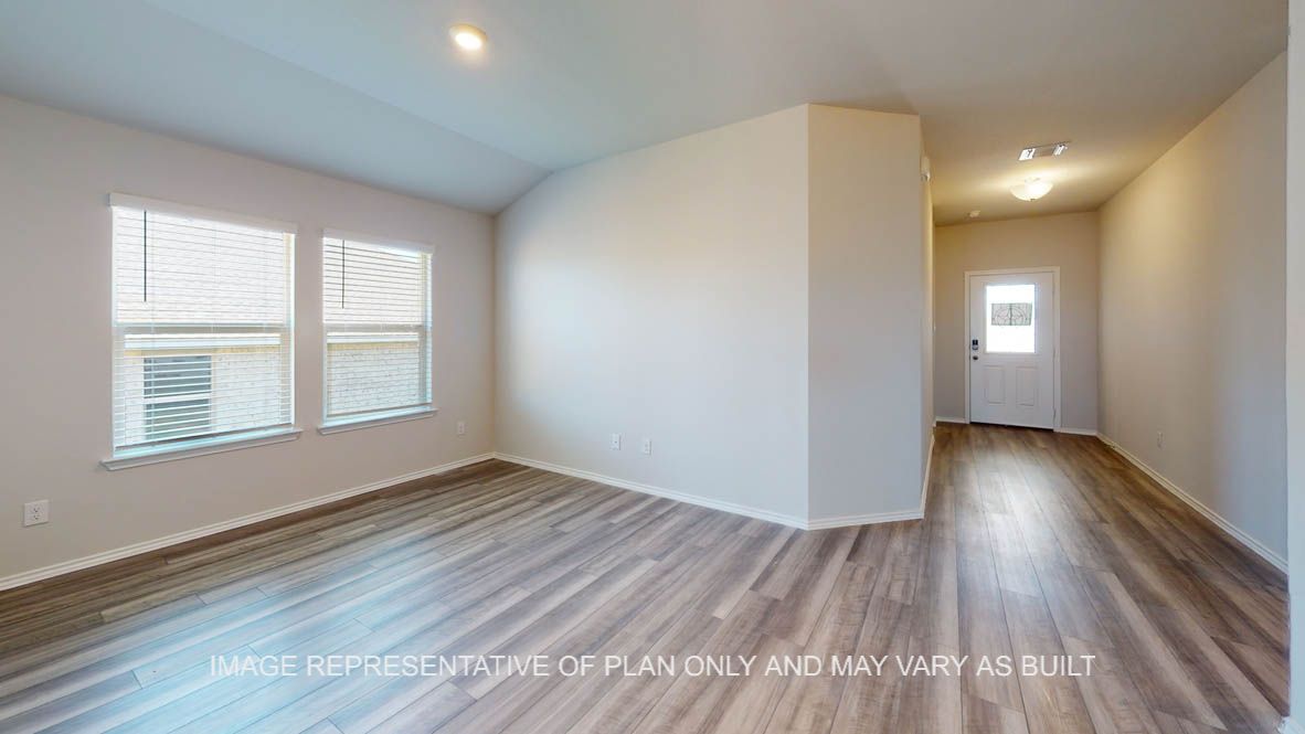 Prescott entry with view of front door into living room with vinyl plank flooring throughout.