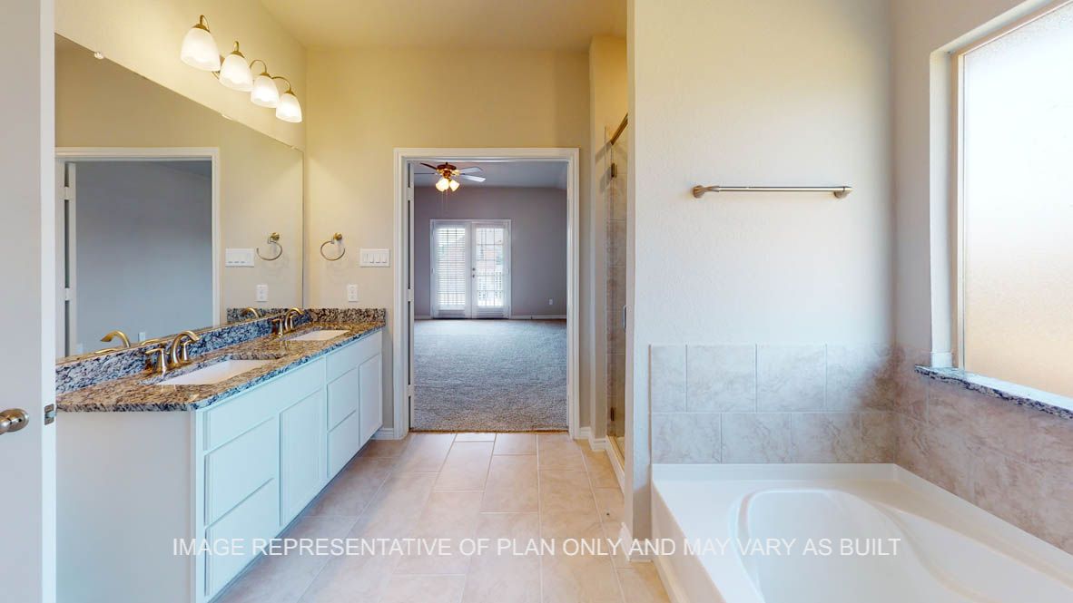 Kiawa primary bathroom with garden tub and white cabinets and granite countertops.