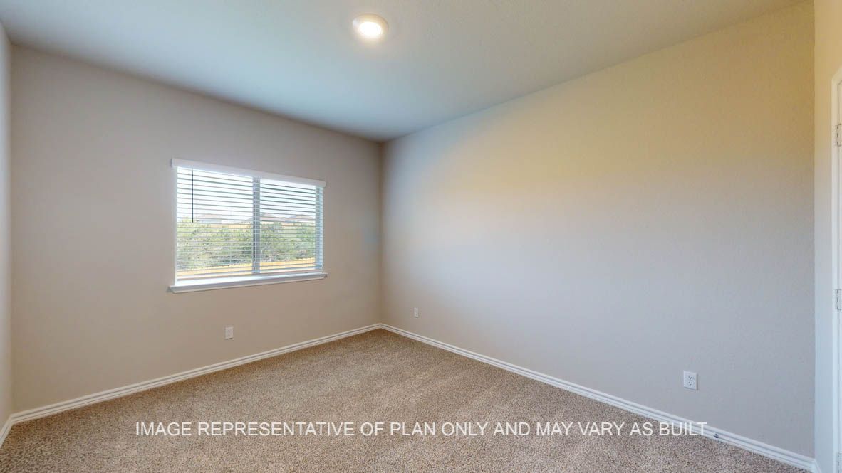 Kiawa secondary bedroom with carpet flooring and window.