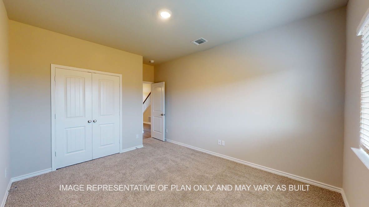 Kiawa secondary bedroom downstairs with carpet flooring.