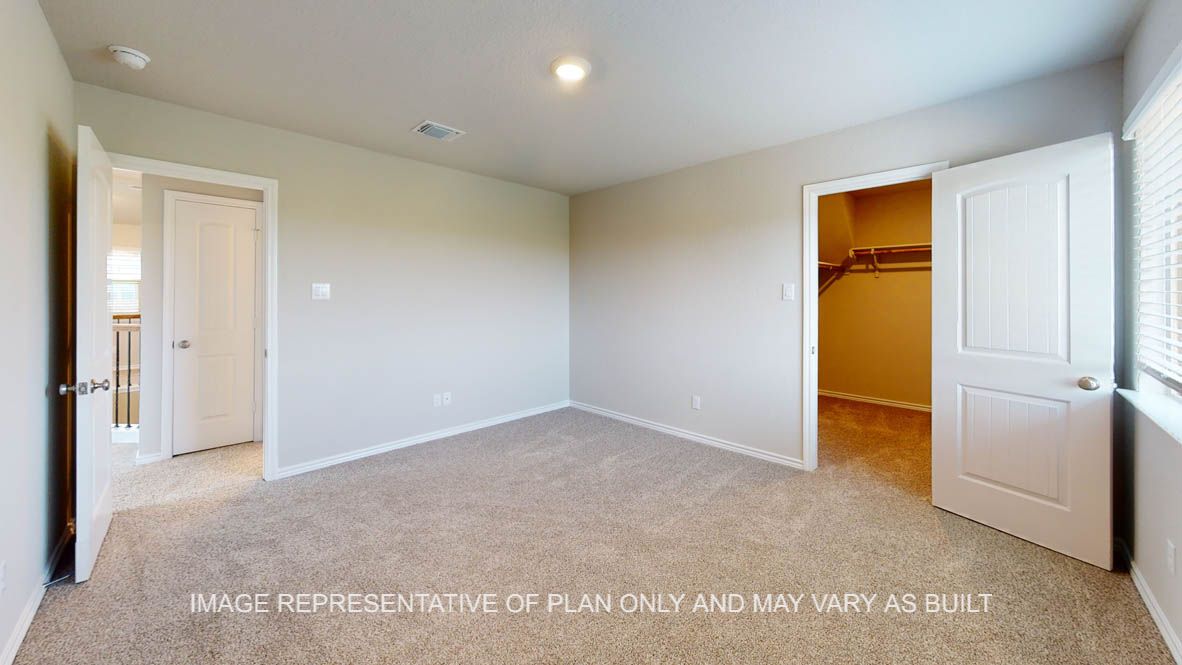 Kiawa secondary bedroom with carpet flooring and walk-in closet.