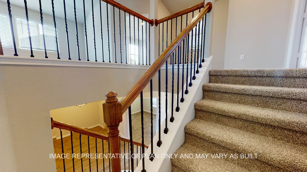 Kiawa stairs with rod iron railing and carpet at the stairs.