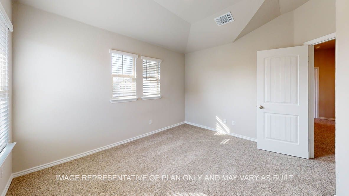 Kiawa secondary bedroom with carpet flooring and window.