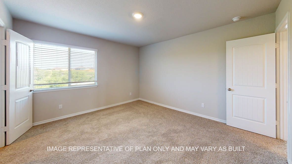 Kiawa secondary bedroom with carpet flooring and window.