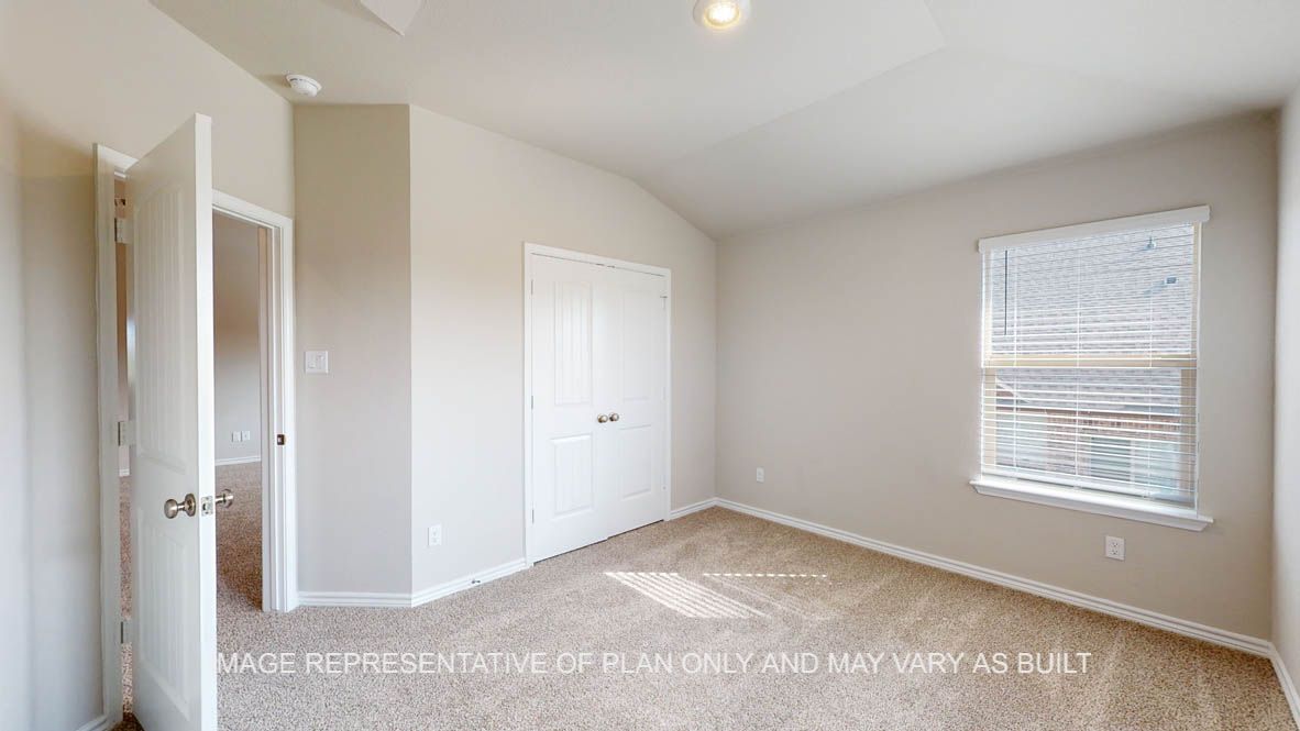 Kiawa secondary bedroom with carpet flooring and window.