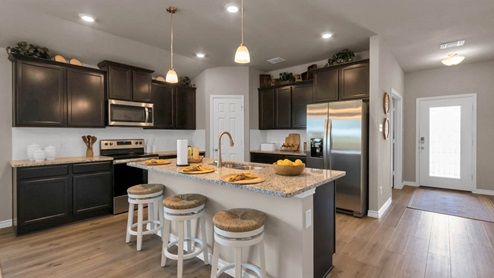 Warrior's Legacy model home kitchen with dark cabinets and granite countertops.