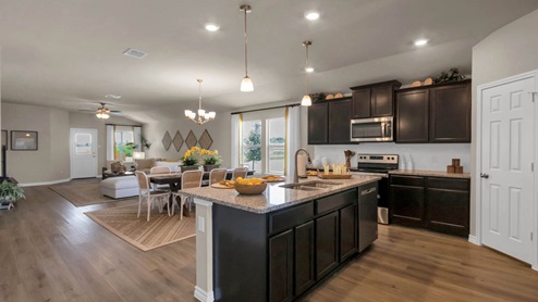 Warrior's Legacy model home kitchen with view of dining and living room.
