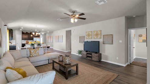 Warrior's Legacy model home living room with open concept of the dining room and kitchen.