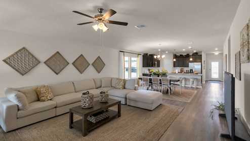 Warrior's Legacy model home living room with open concept of the dining room and kitchen.