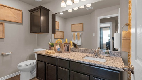 Warrior's Legacy model home secondary bathroom with single vanity sink and mirror.