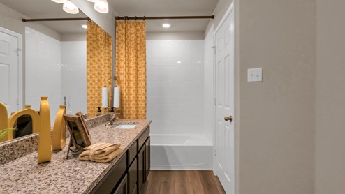 Warrior's Legacy model home secondary bathroom with bathtub and shower combo.
